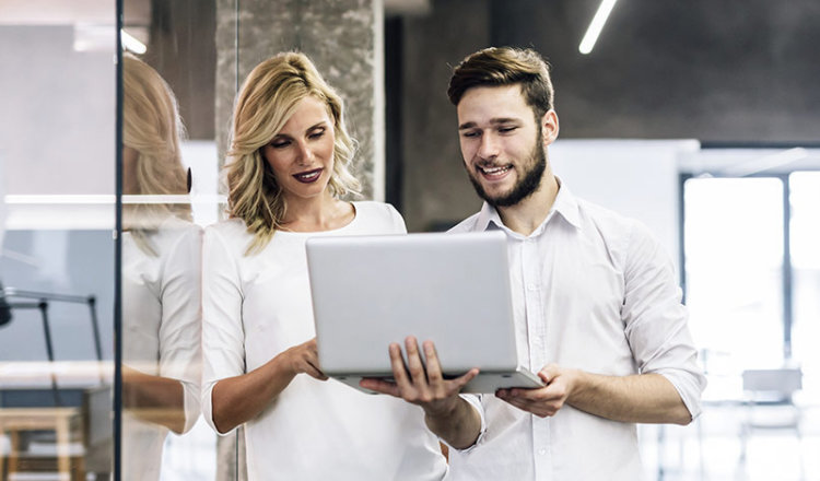 A woman and a man holding a Laptop